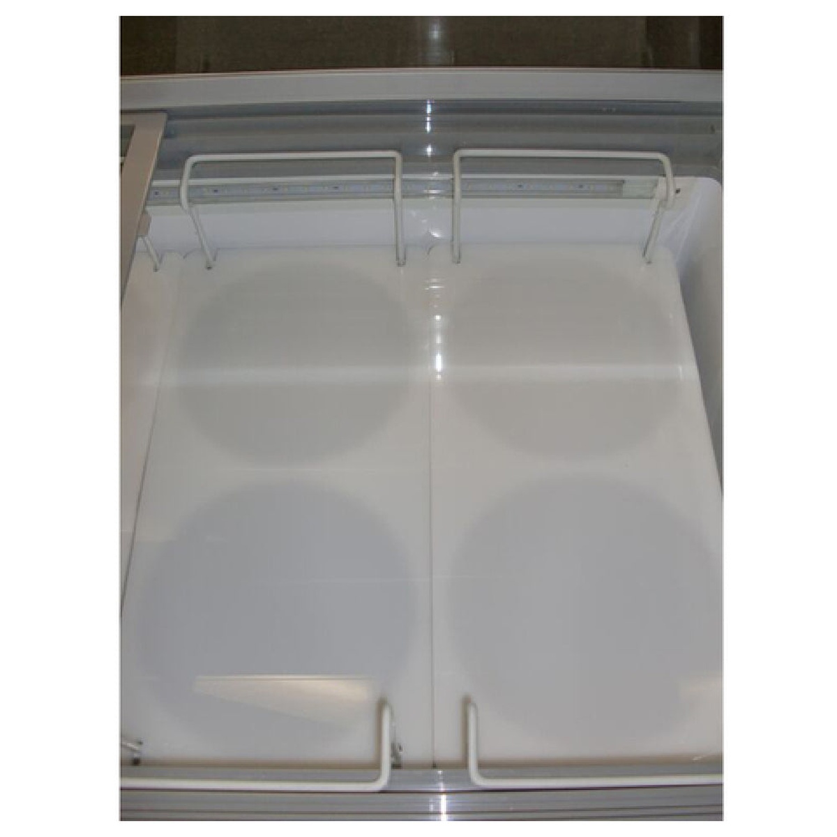 Two white night covers installed across dual basket sections inside a chest freezer cabinet