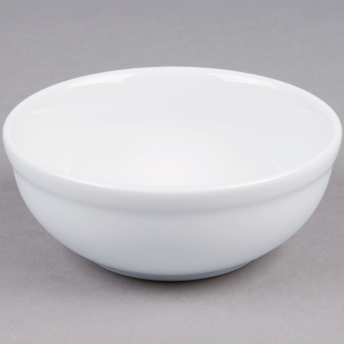 Tuxton ALB-1503 Alaska 17 oz. bright white china nappie bowl with rolled edge, viewed from a three-quarter angle