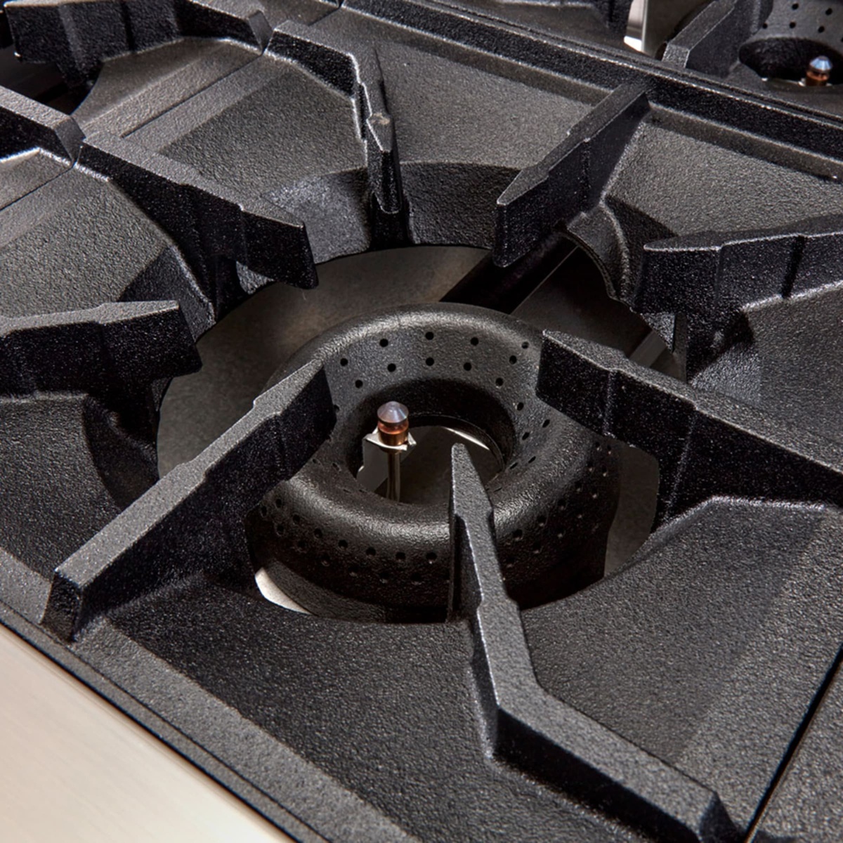 Close-up of heavy cast iron grate over an open gas burner