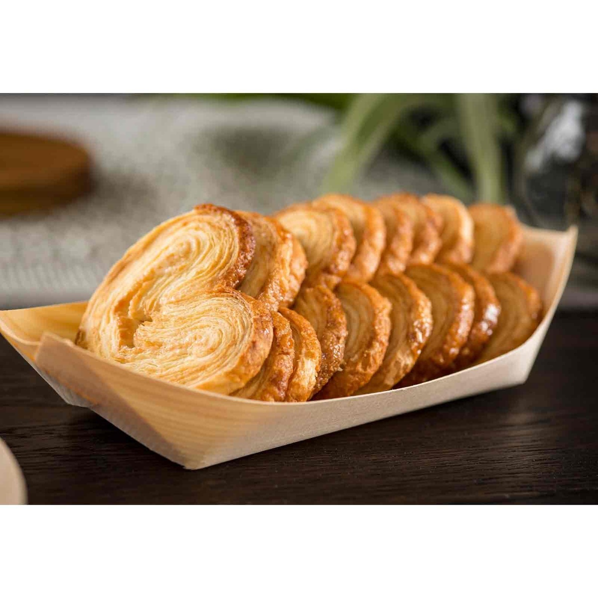 Medium disposable poplar wood serving boat filled with golden brown pastries