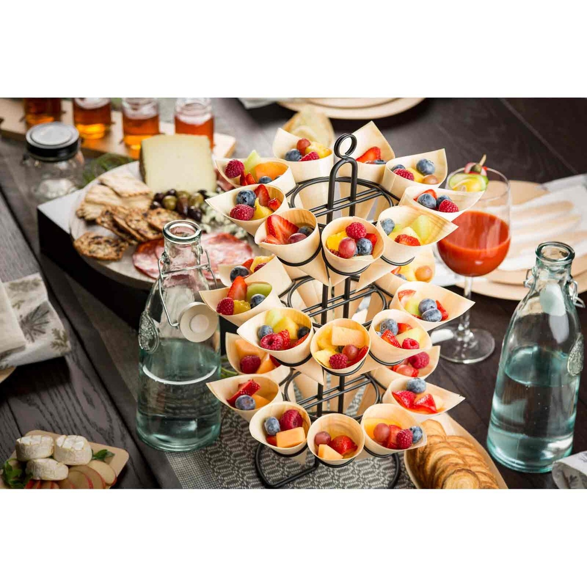 Catering display stand filled with wooden cones containing fresh fruit and berries