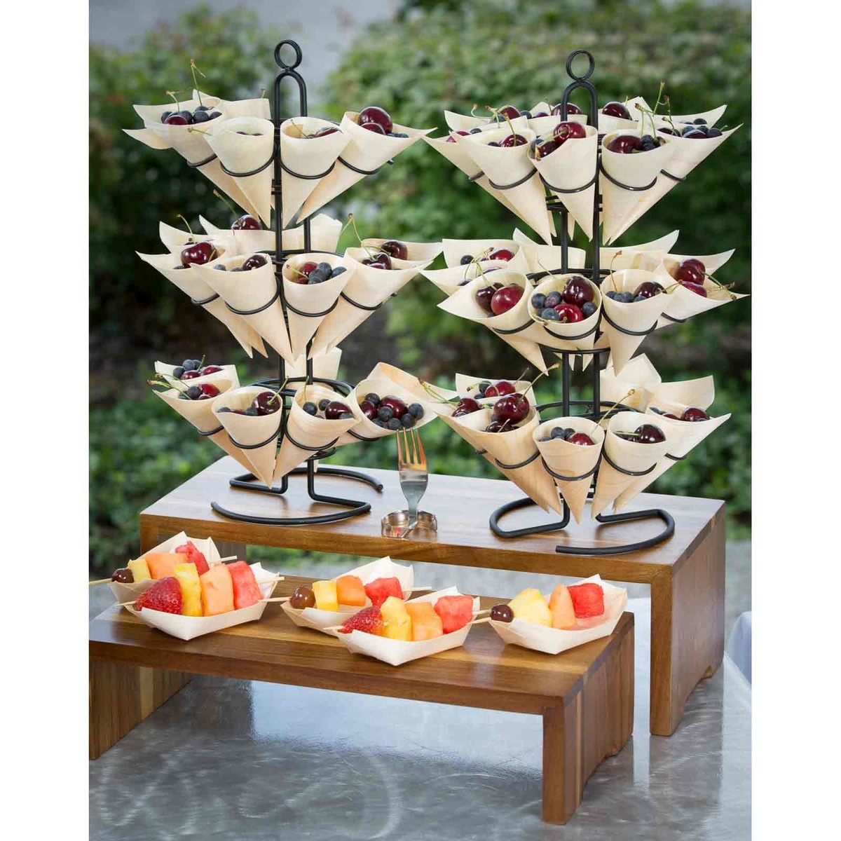 Wooden serving cones displayed in a black wire stand filled with fresh fruit