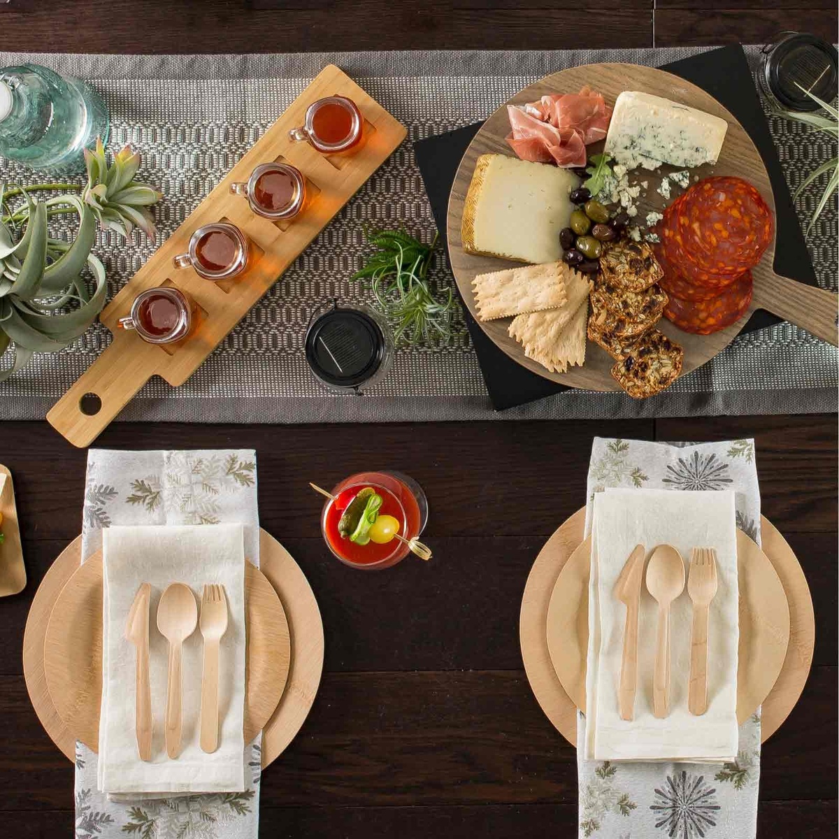 Table setting featuring round bamboo plates with cutlery and appetizers