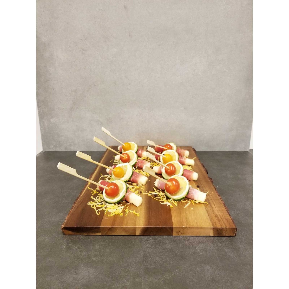 Bamboo paddle picks securing appetizers on a wooden serving board