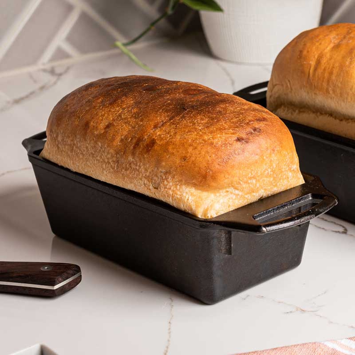 Freshly baked loaf of bread inside a Lodge cast iron loaf pan