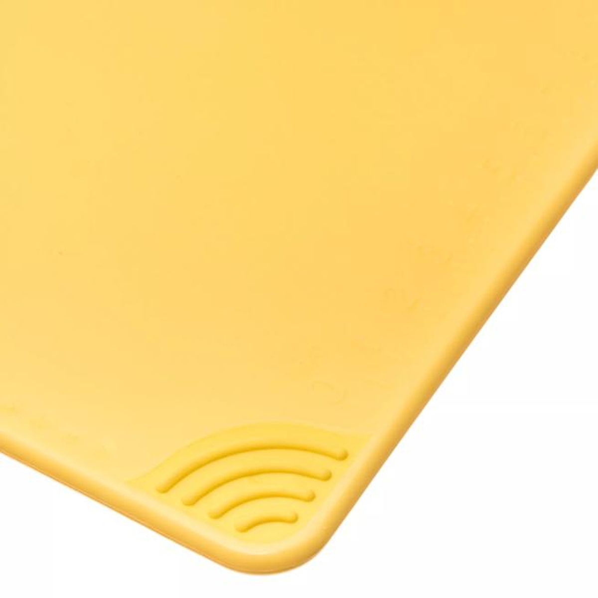 Close-up of the molded anti-slip grip corner on the San Jamar yellow cutting board