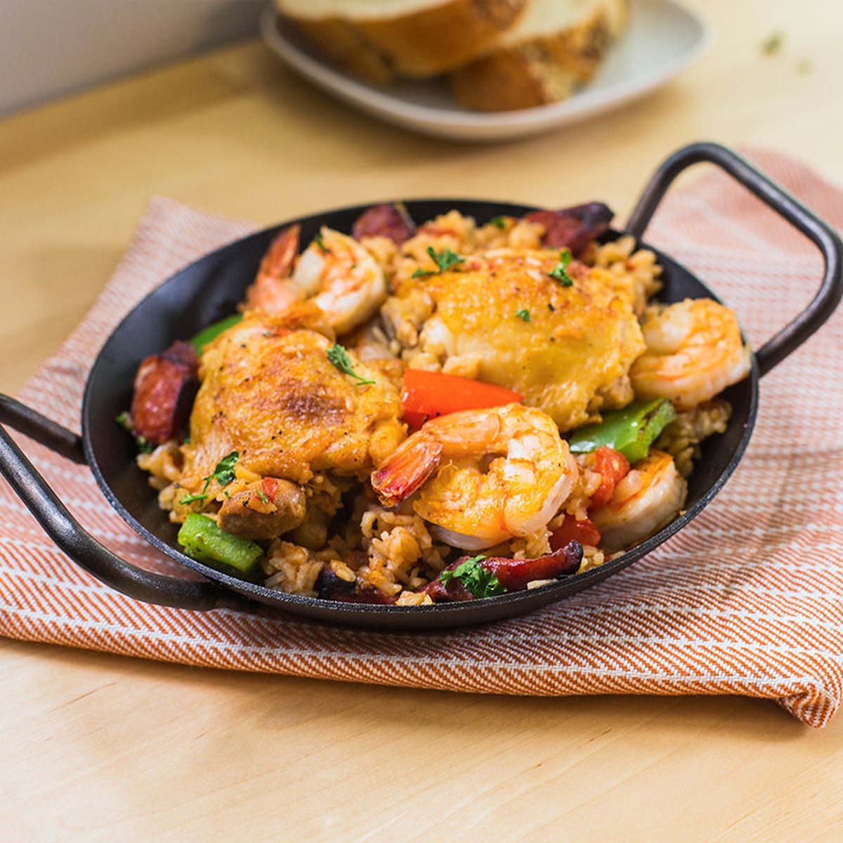 Carbon steel skillet filled with cooked shrimp and chicken paella