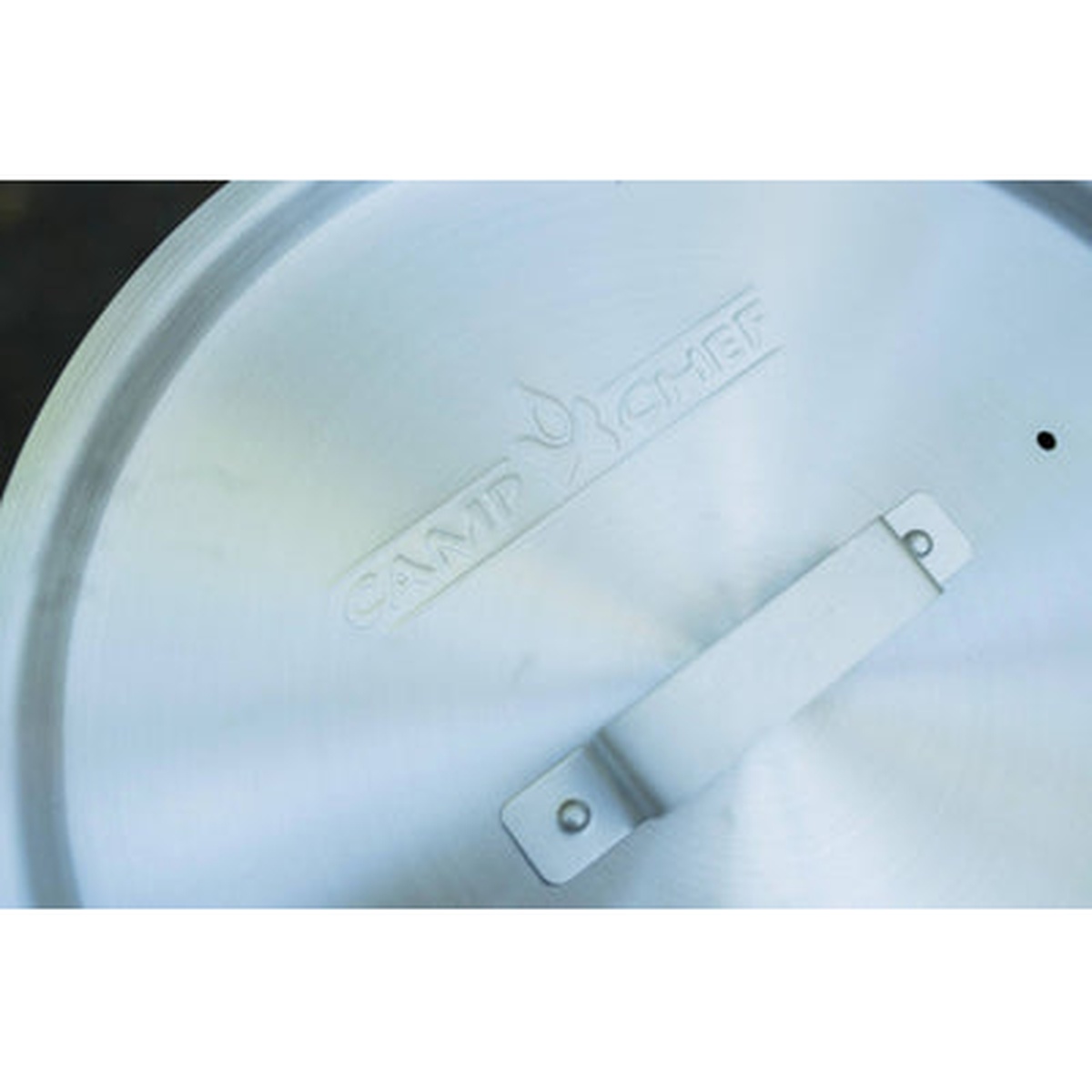 Close-up of the Camp Chef branded aluminum pot lid with center handle