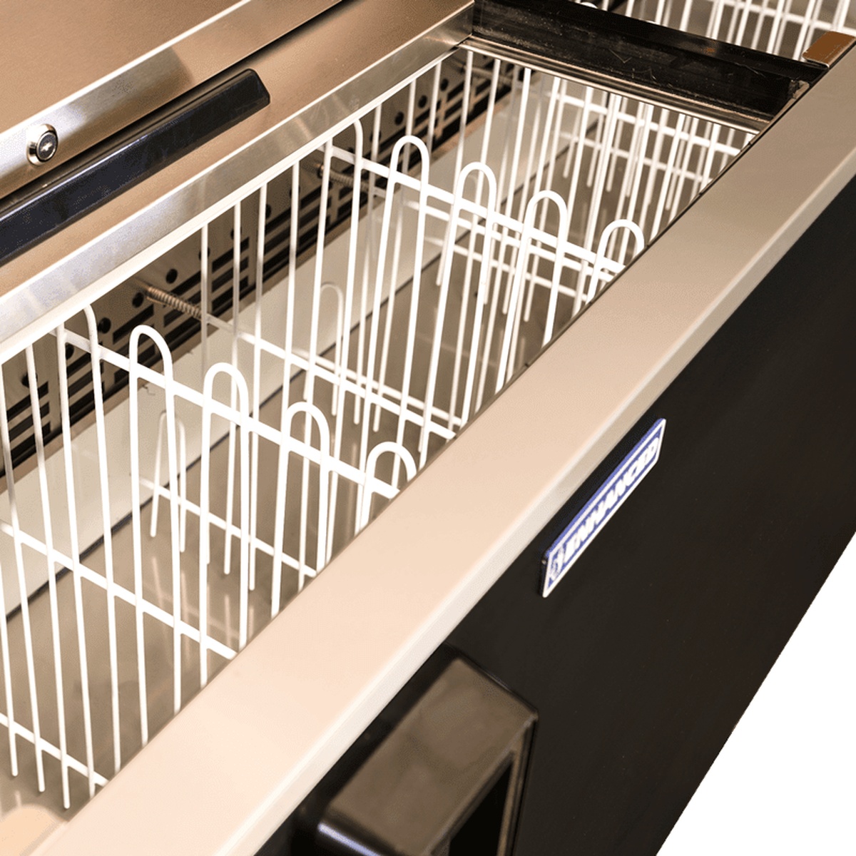 Interior of Enhanced EBC-95-HC bottle cooler showing white wire basket dividers and stainless steel liner