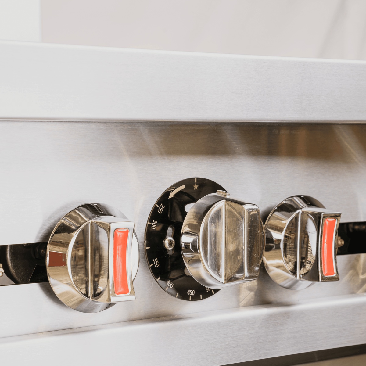Close-up of ER-4 Enhanced gas range control knobs showing chrome burner knobs and oven thermostat dial with temperature markings from 250 to 450 degrees