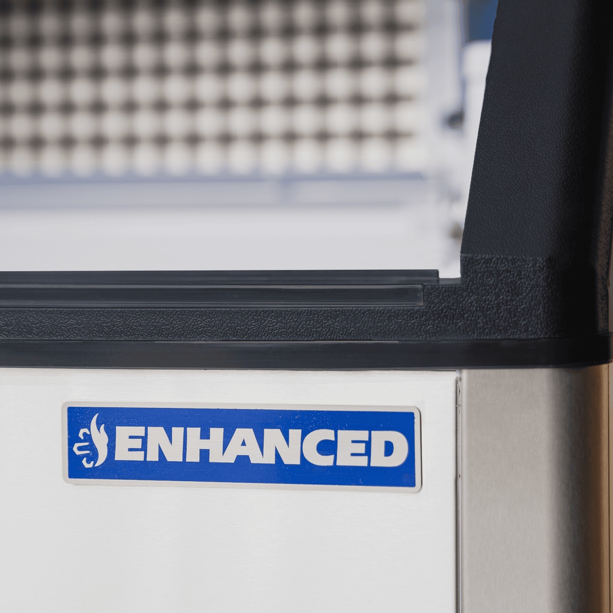Close-up of Enhanced brand badge on the ESK-129S undercounter ice machine stainless steel cabinet