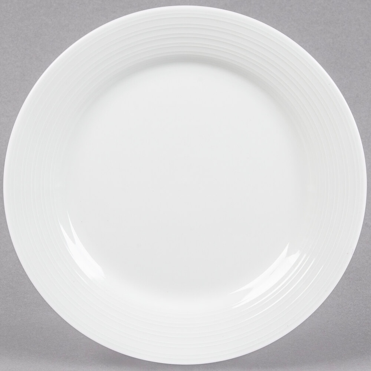 Tuxton Pacifica FPA-090 9-inch bright white embossed china plate, top view on gray background