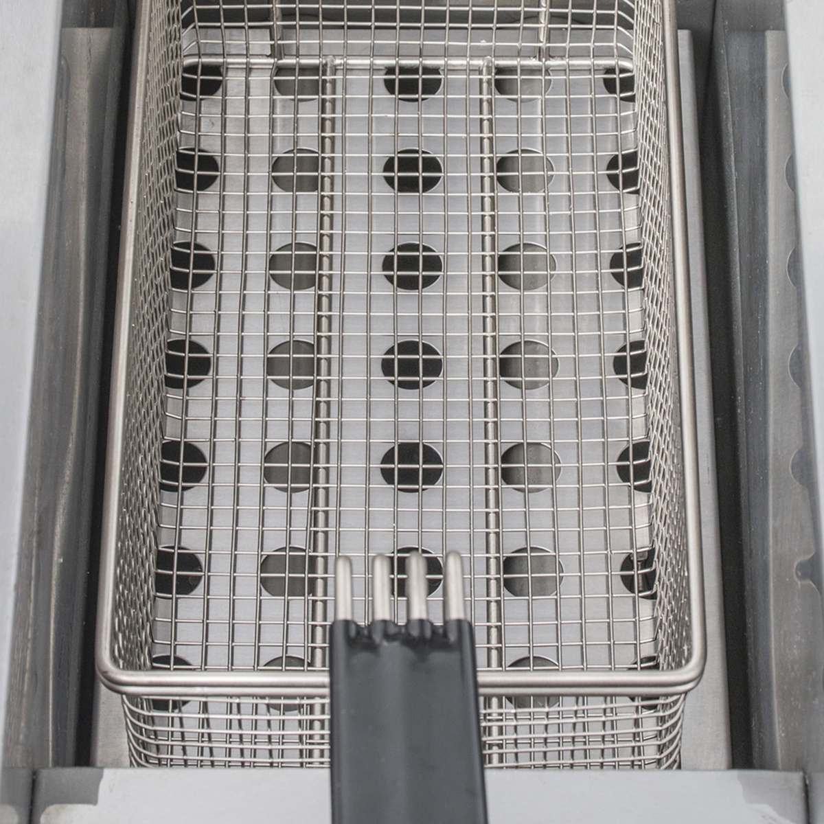 Close-up of fry basket sitting inside the fryer vat