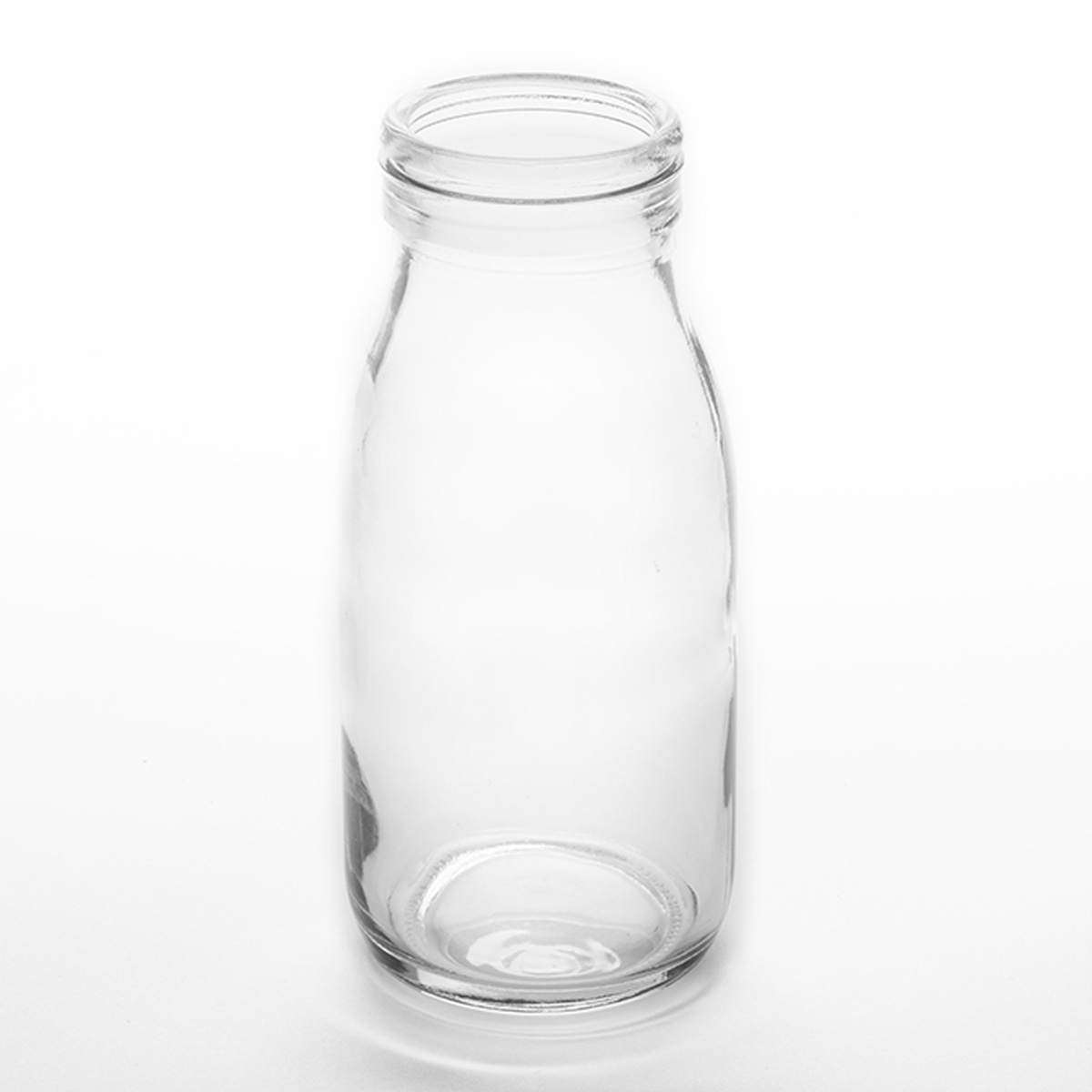 American Metalcraft GMB16 clear 16 oz glass milk bottle, 2-3/4 inch diameter by 6-1/2 inch tall, shown on white background