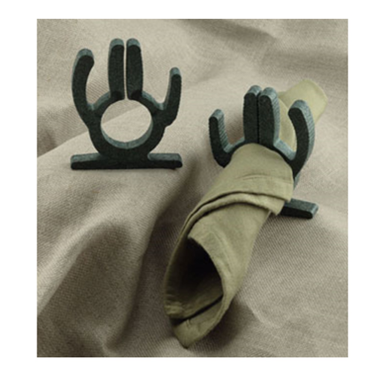 Two dark green cactus-shaped napkin holders by H.S. Inc., one empty and one holding a folded cloth napkin