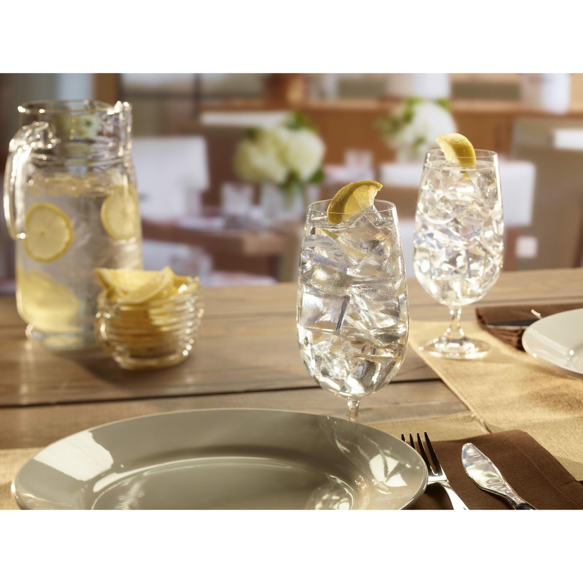 Glasses of water with crescent ice and lemon slices on a restaurant table