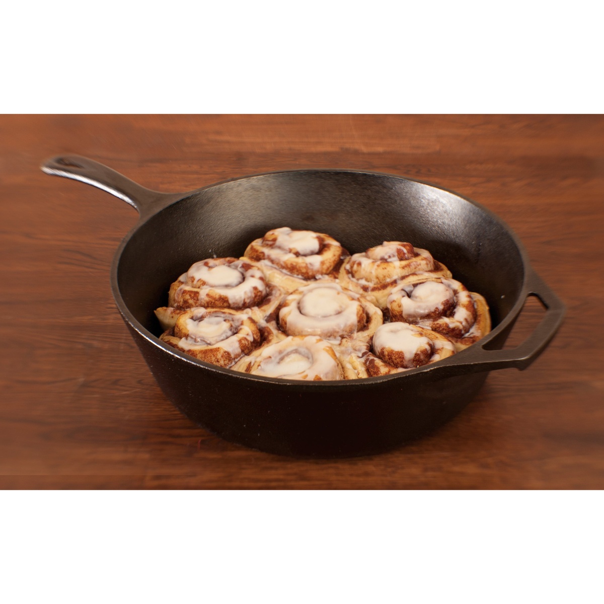 Cinnamon rolls baking in a Lodge deep cast iron skillet