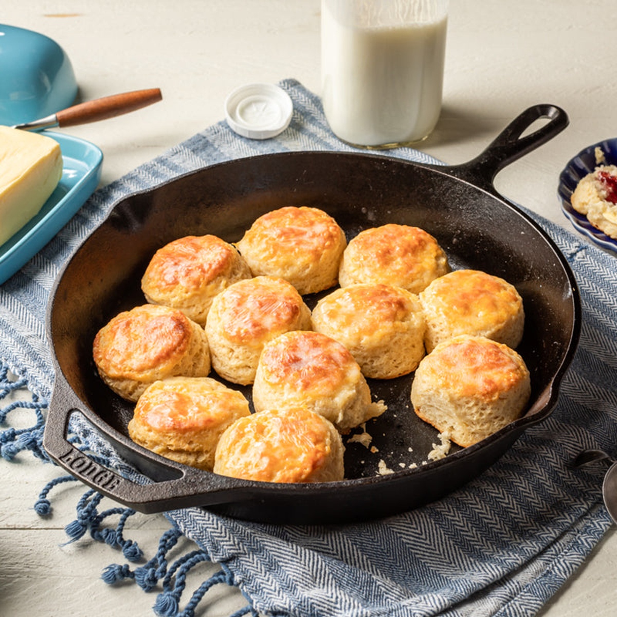 Lodge cast iron skillet with freshly baked biscuits on a blue cloth