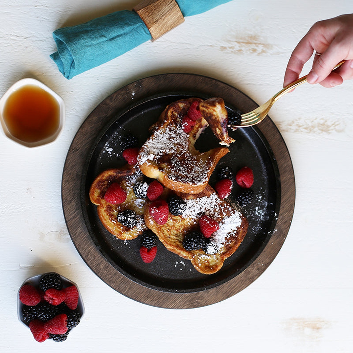 French toast served on a round cast iron griddle with berries