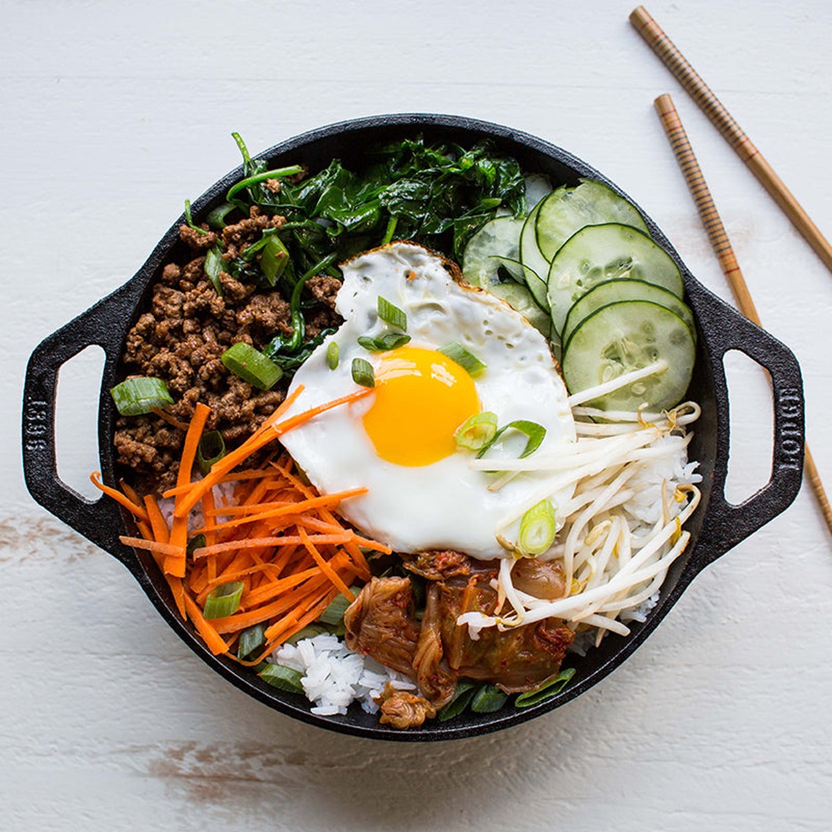 Lodge 9 inch cast iron mini wok filled with a colorful stir fry meal