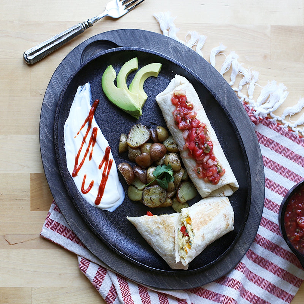 Top down view of a breakfast meal served on an oval cast iron griddle