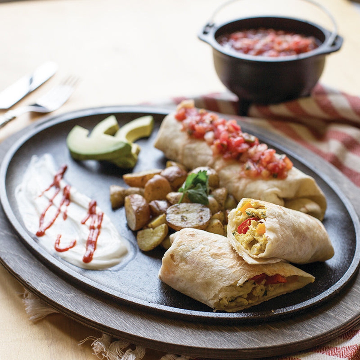Breakfast burritos served on a sizzling cast iron oval griddle