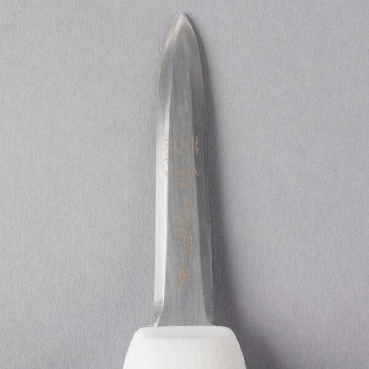 Close-up of the high-carbon stainless steel blade of the Mercer Culinary oyster knife showing ground edges and rounded tip