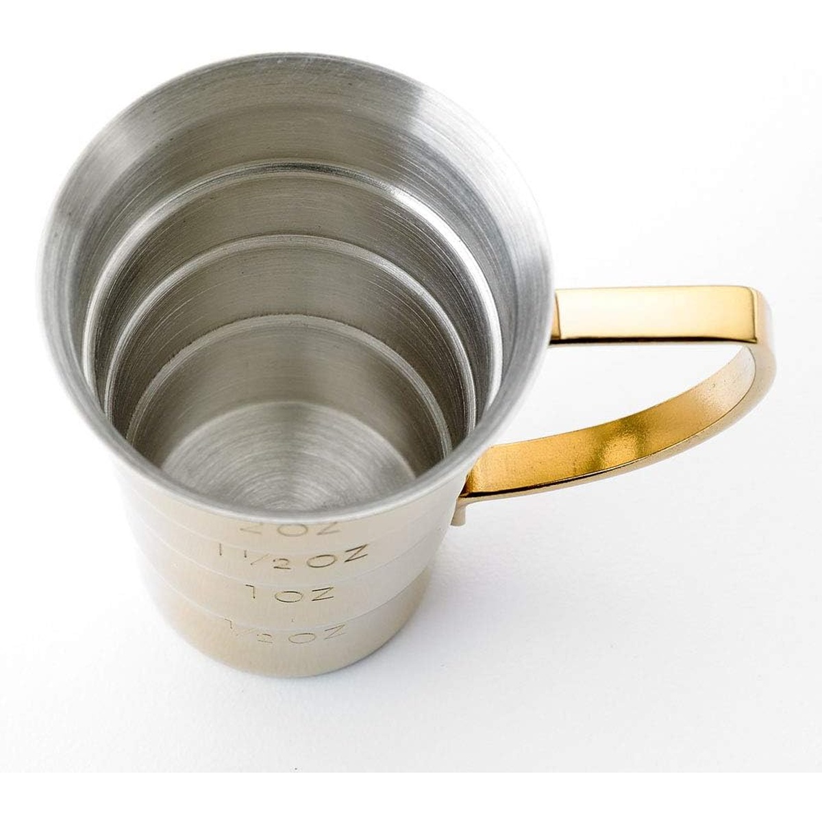Top-down view inside the Barfly gold jigger showing brushed stainless steel interior with stepped oz measurement rings