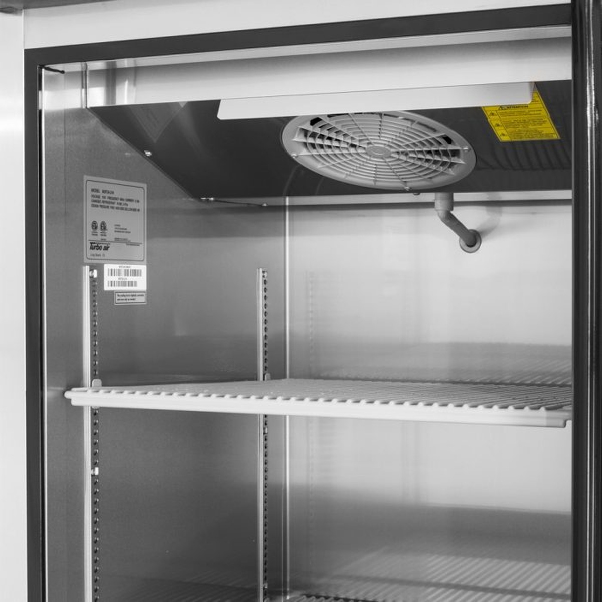 Reach-in freezer interior with adjustable shelf and evaporator fan