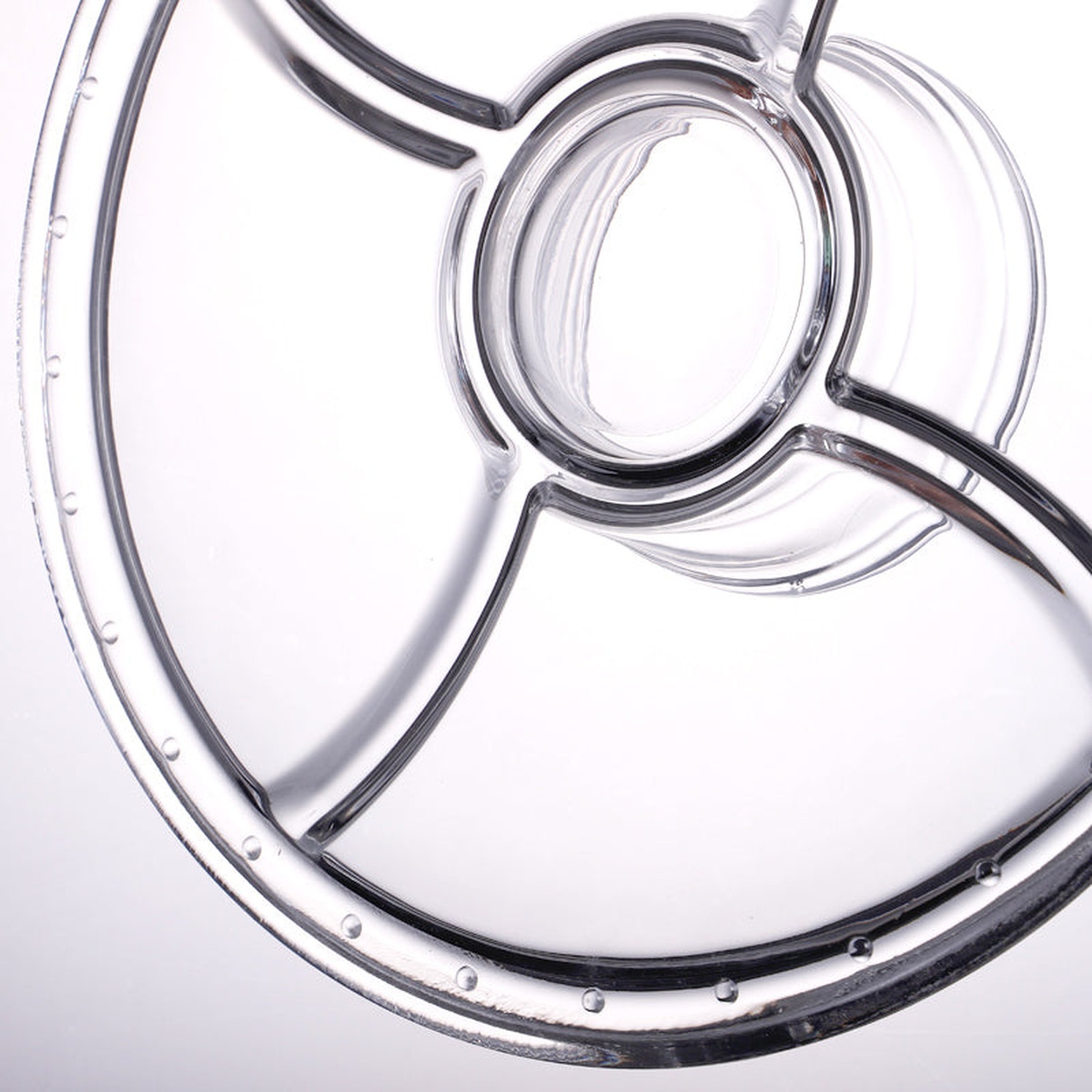 Close-up underside view of the glass cake stand base plate showing three-section divided pattern