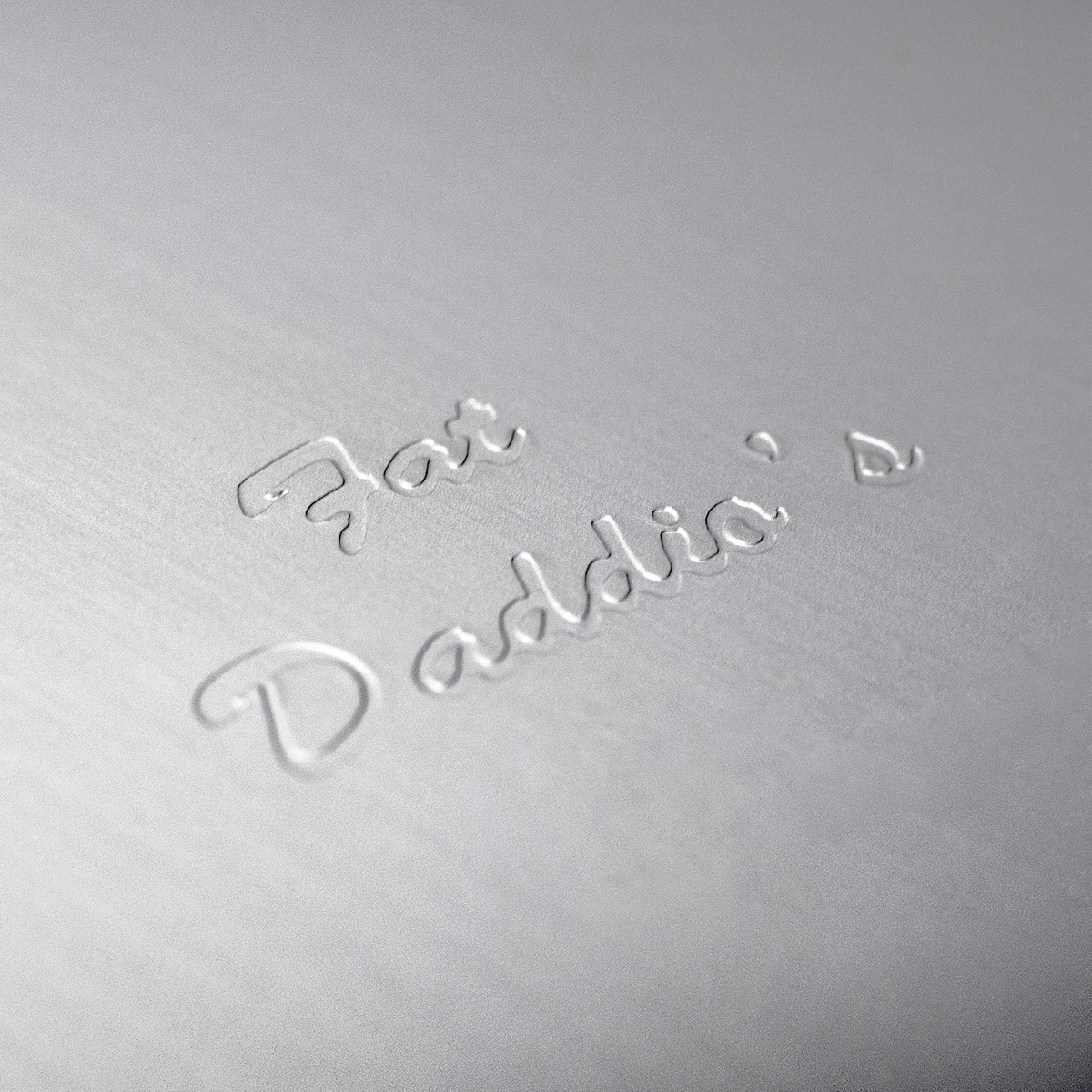 Close-up of embossed Fat Daddio's signature on the anodized aluminum pan surface