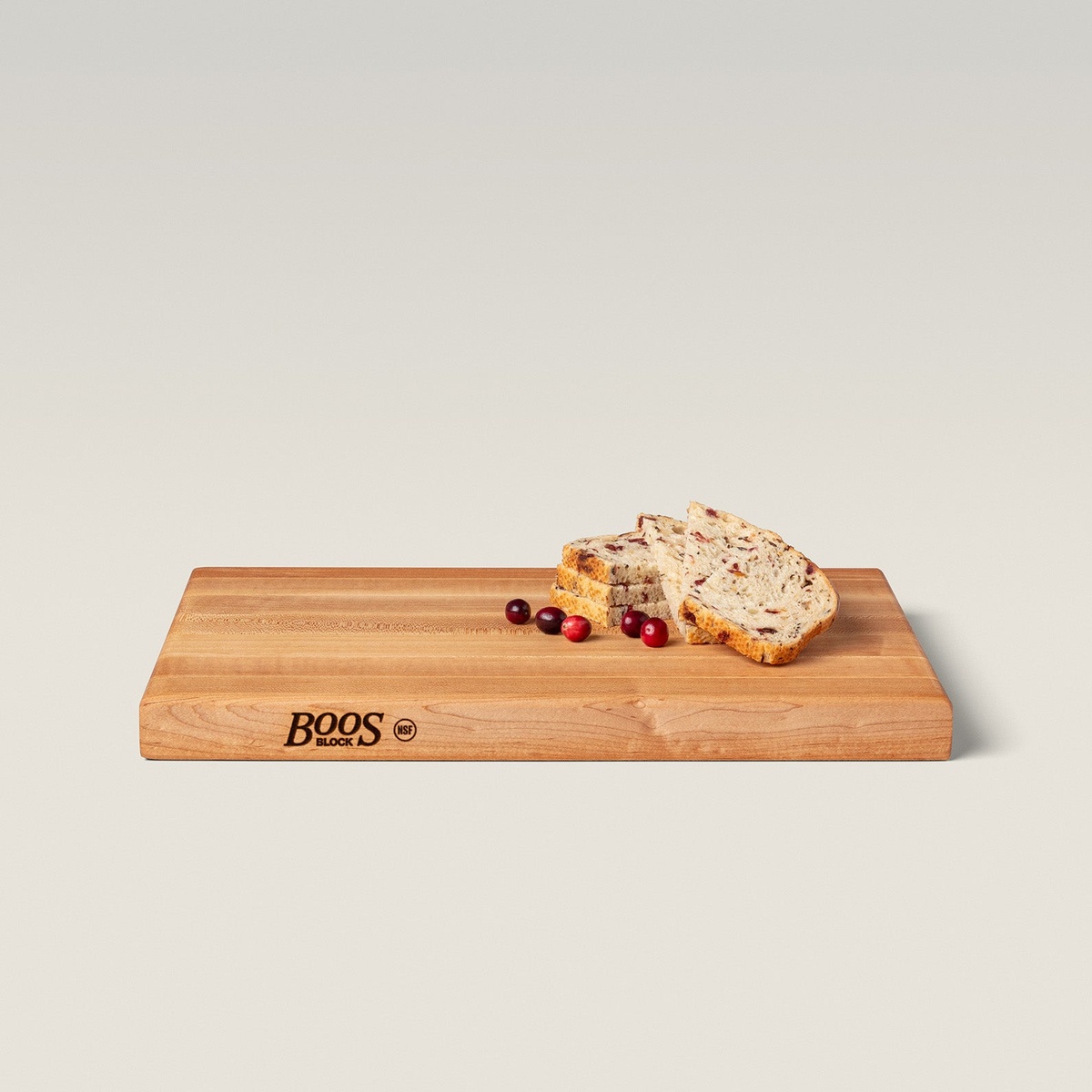 John Boos R01 maple cutting board at an angle with sliced bread and cranberries on the surface