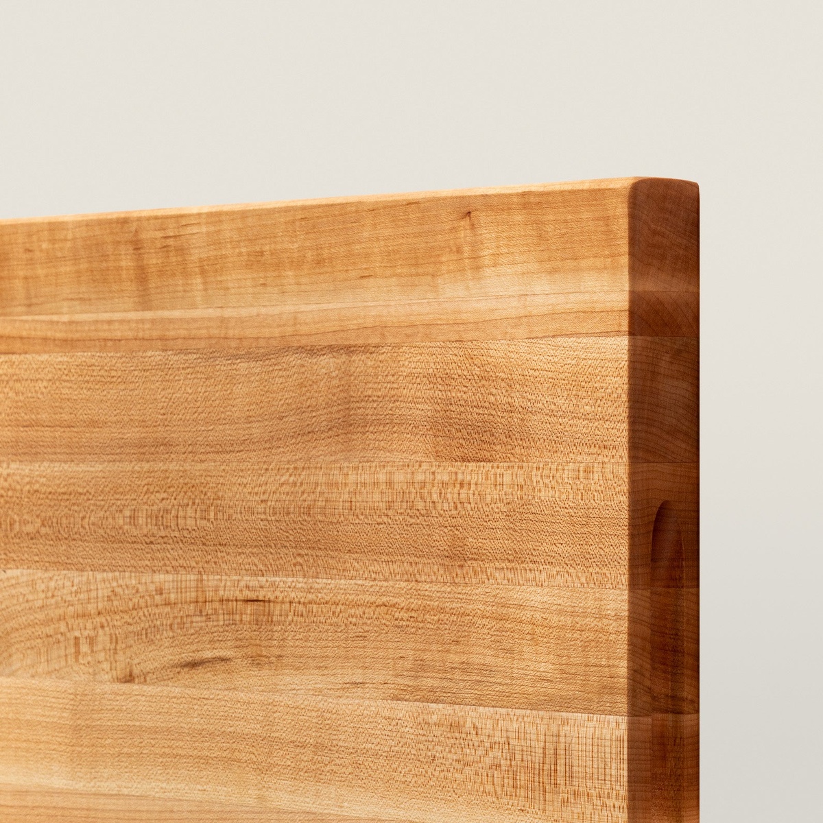 Close-up corner detail of John Boos R03 maple cutting board showing edge-grain layers and recessed finger grip