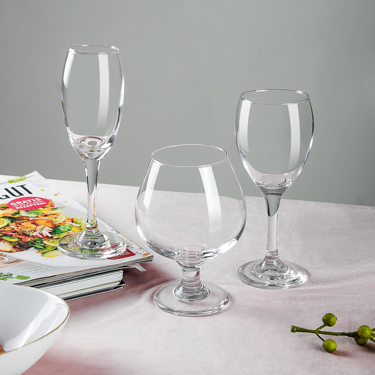 Assorted Enhanced Glassware stemware including a champagne flute, snifter, and wine glass displayed on a table