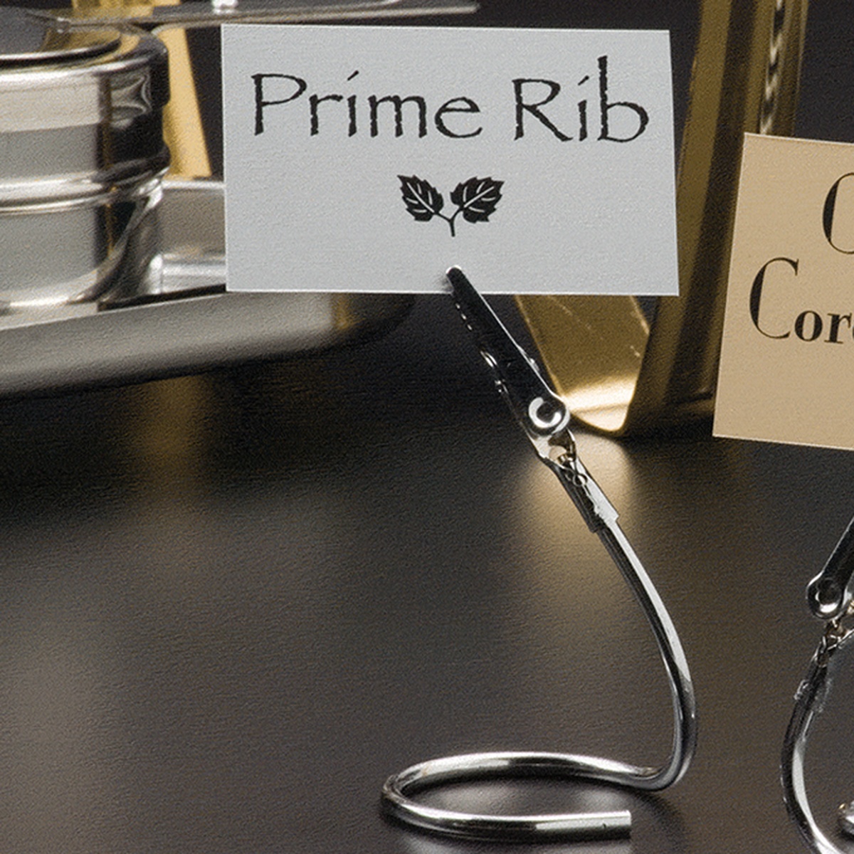 American Metalcraft SAC40 stainless steel alligator clip card holder displaying a Prime Rib menu card on a dark buffet surface