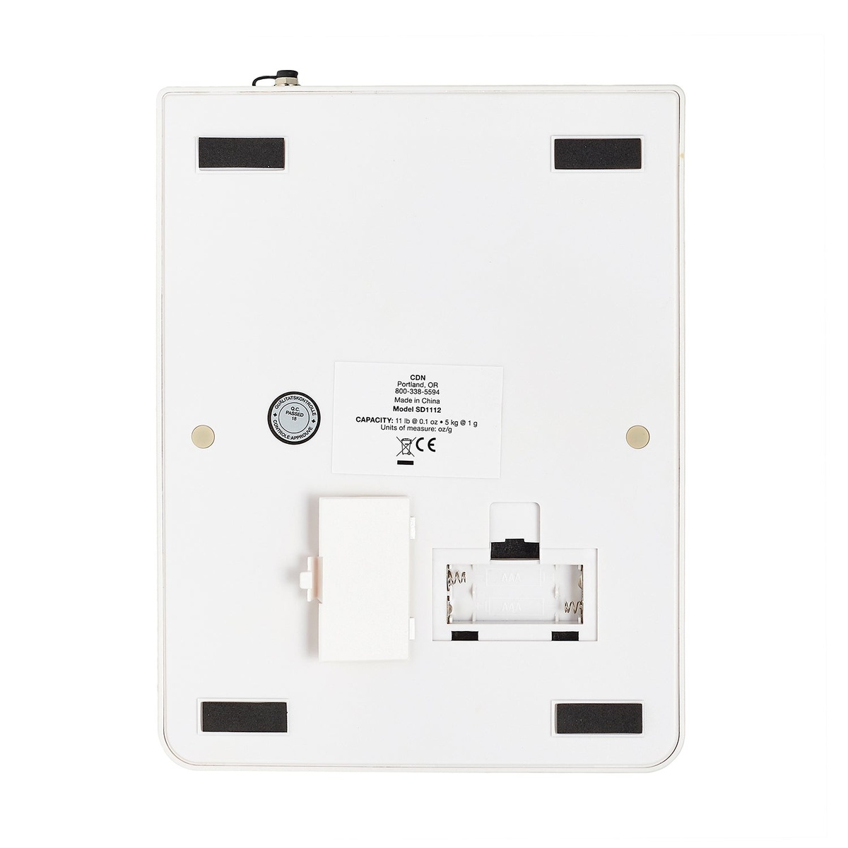 CDN SD1112 scale bottom view showing battery compartment, model label, and non-slip corner pads