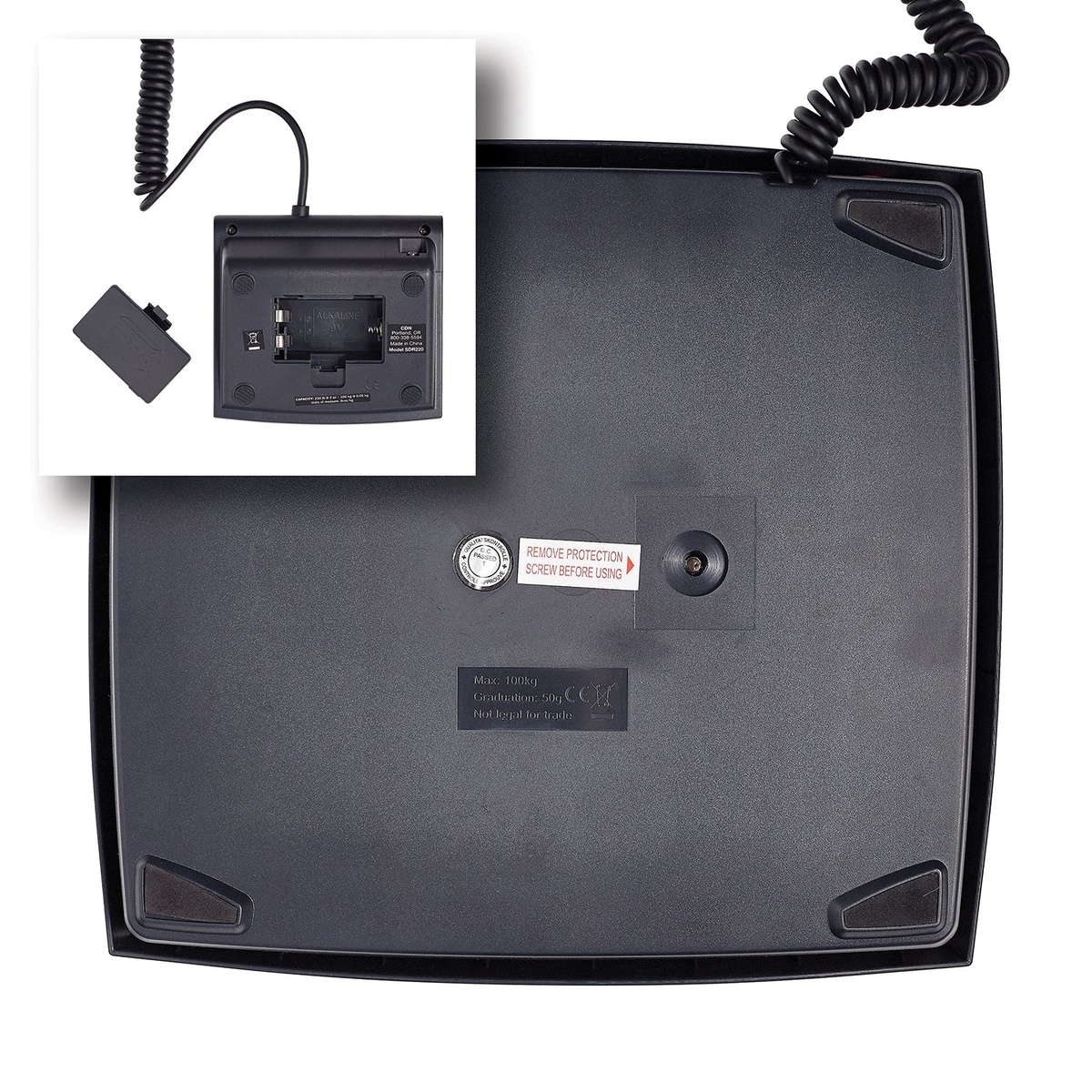 Underside of CDN SDR220 scale platform showing product label with 100 kg max capacity and 50g graduation, with inset of display battery compartment