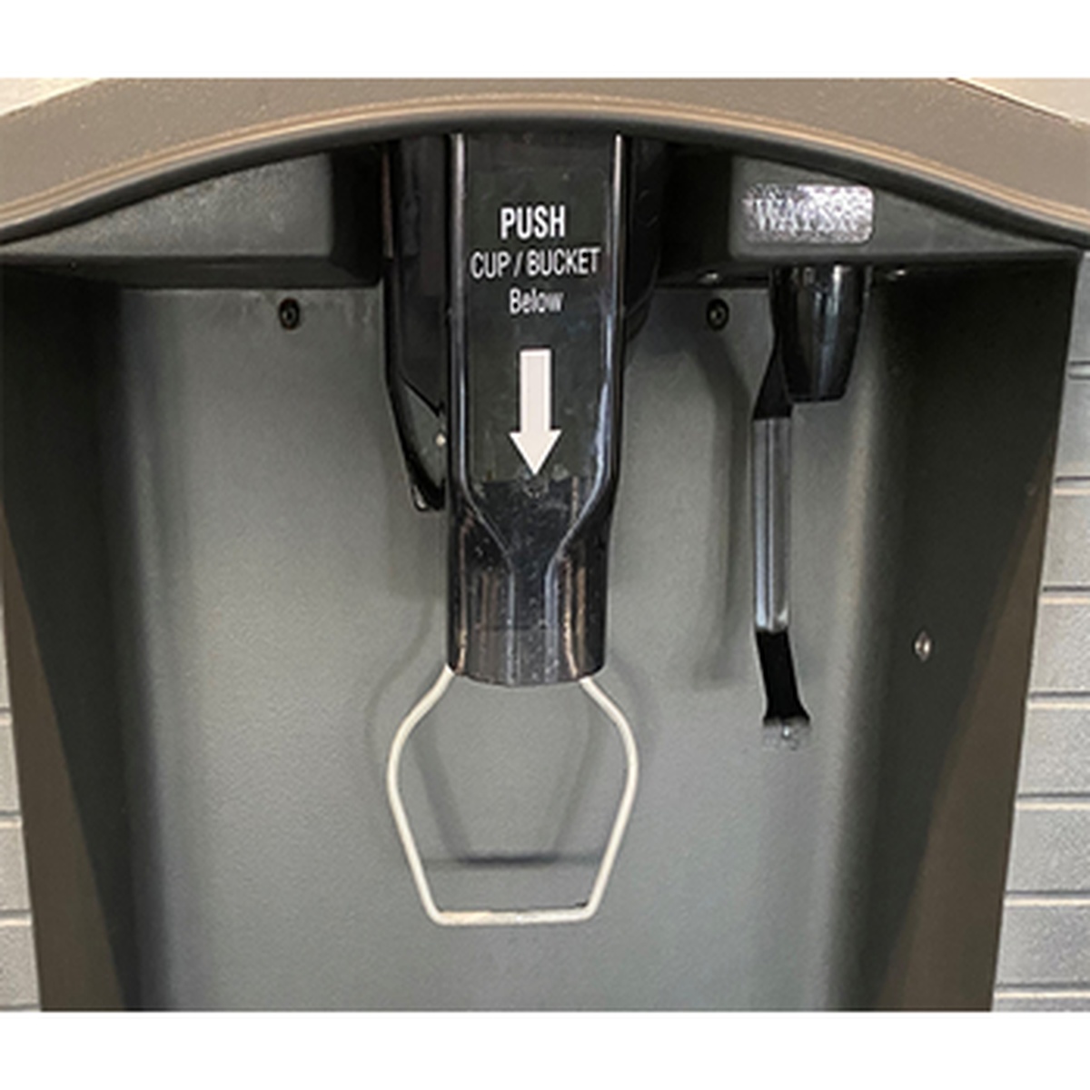 Close-up of Manitowoc SPA162 touchless ice dispenser chute showing push cup/bucket lever mechanism