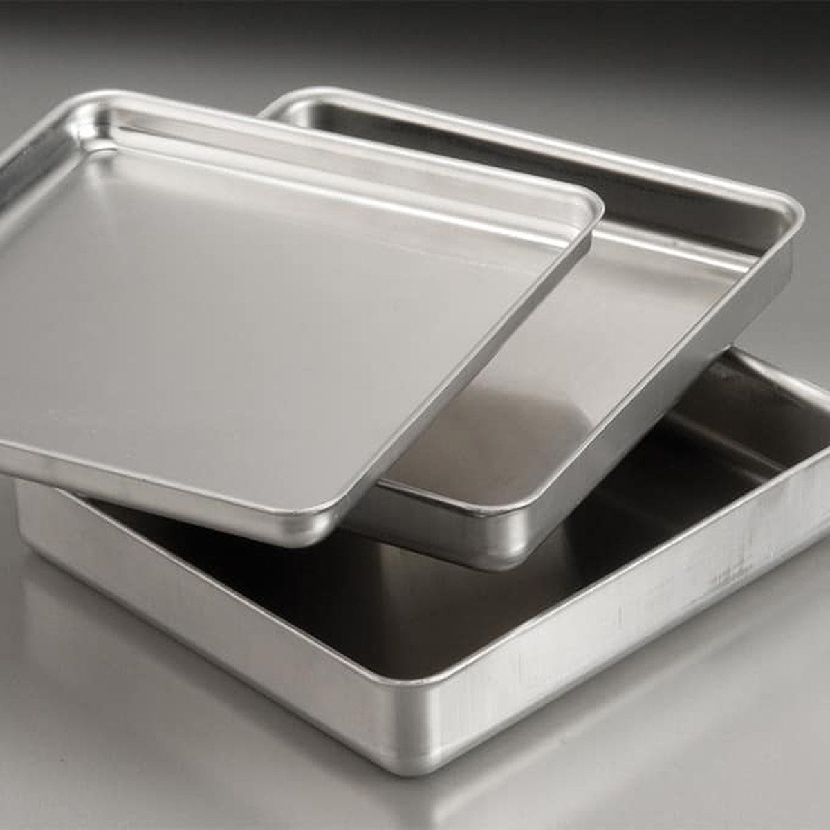 Two stacked American Metalcraft SQ820 square aluminum pizza pans with raised sides on a neutral surface