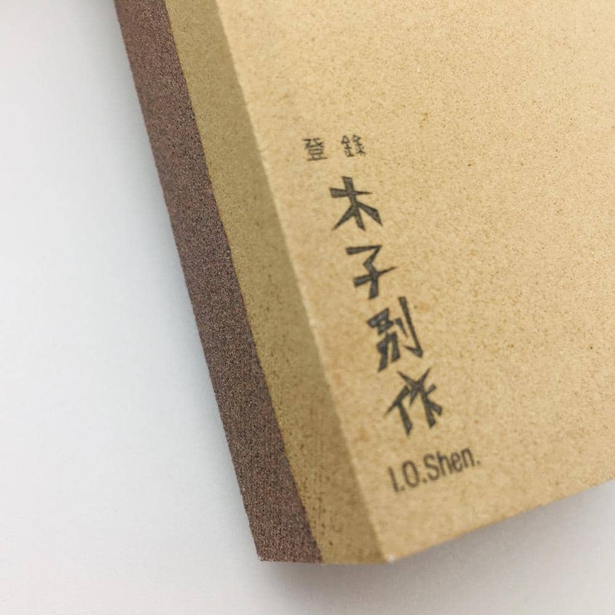 Close-up detail of the Japanese characters and I.O. Shen branding on the whetstone surface