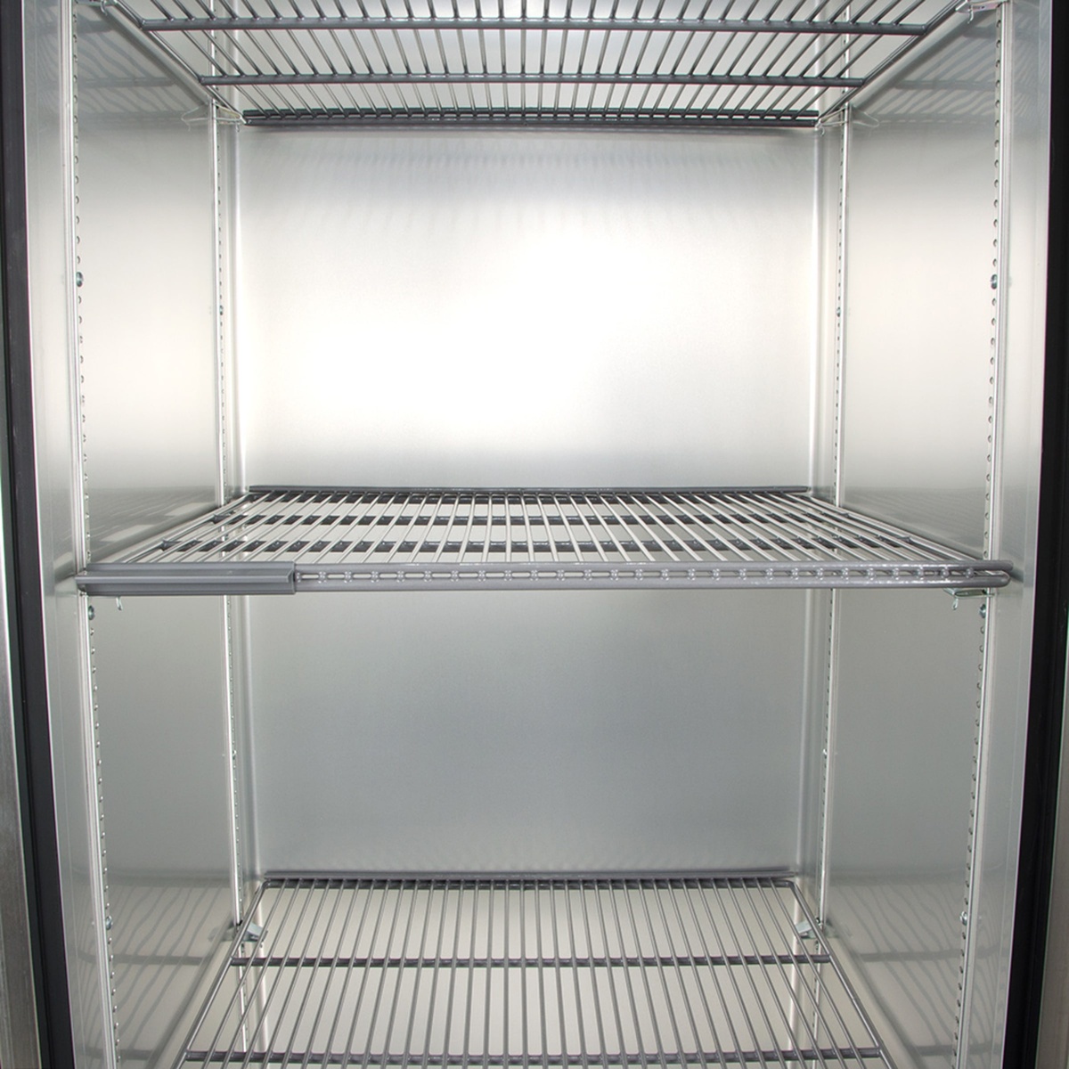 Inside view of reach-in refrigerator showing wire shelves and aluminum interior walls