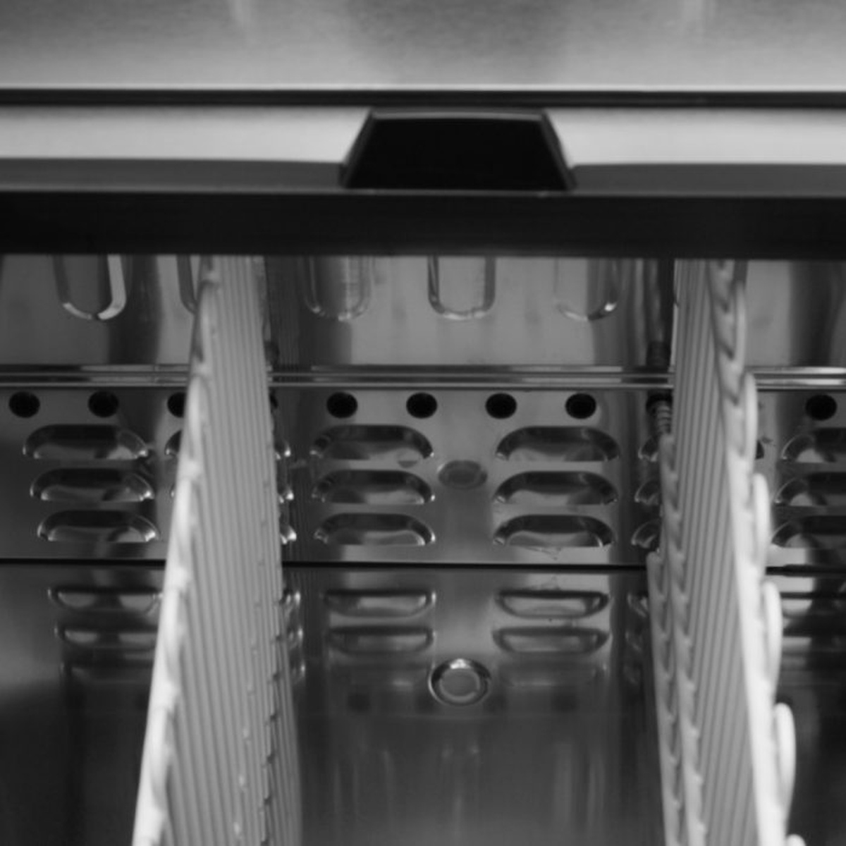 Interior view of bottle cooler showing stainless steel walls and adjustable dividers