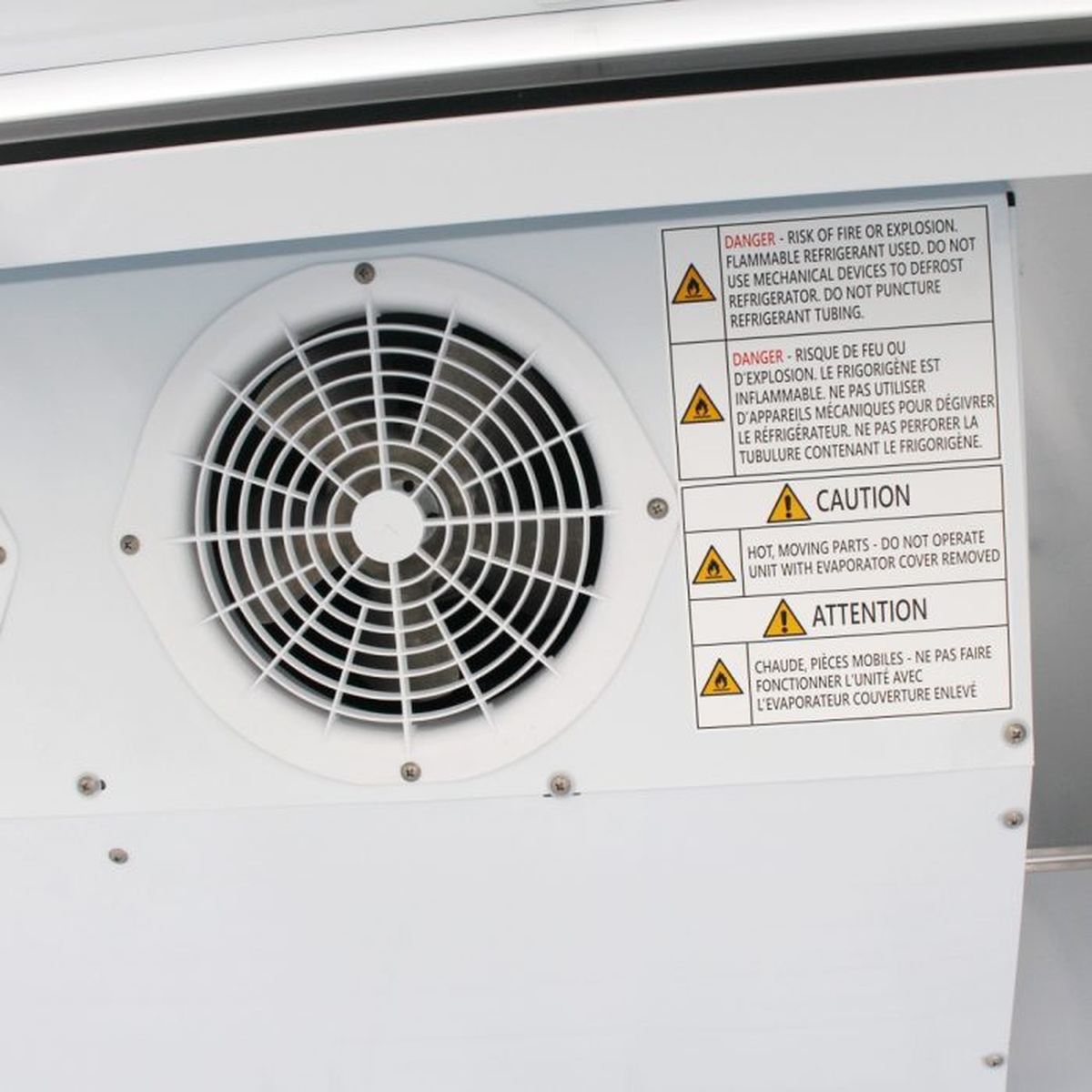Close-up of Turbo Air ice merchandiser condenser fan and safety labels