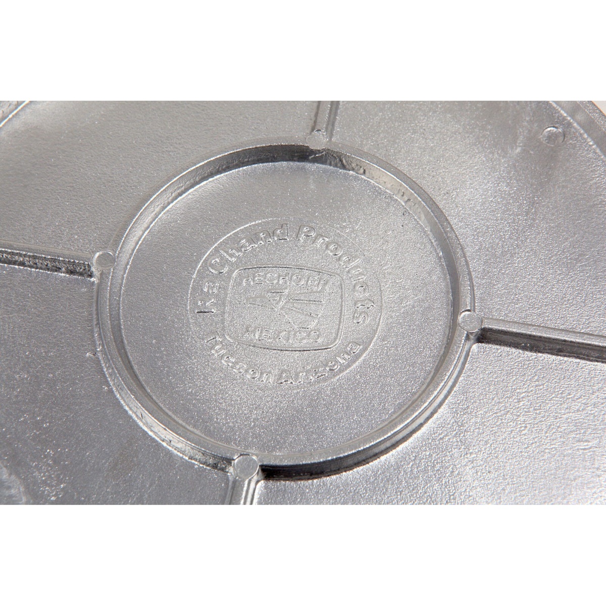 Close-up of Ra Chand Products brand embossing on cast aluminum tortilla press plate, reading Hecho en Mexico and Tucson Arizona
