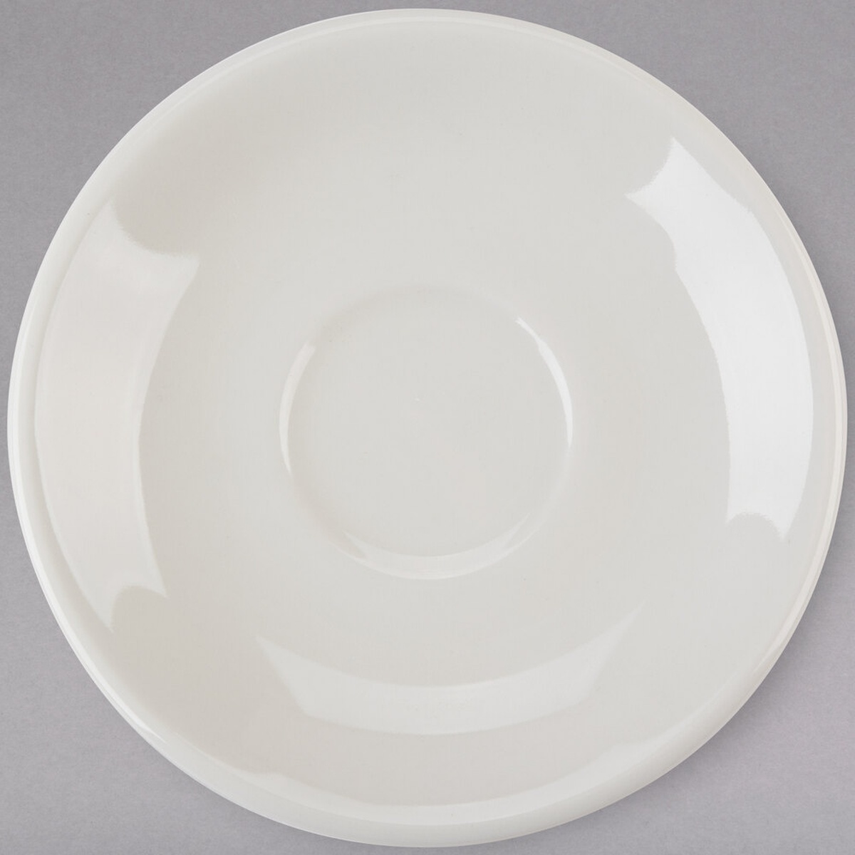 Tuxton TRE-036 5-inch round eggshell coupe demitasse saucer viewed from above on gray background