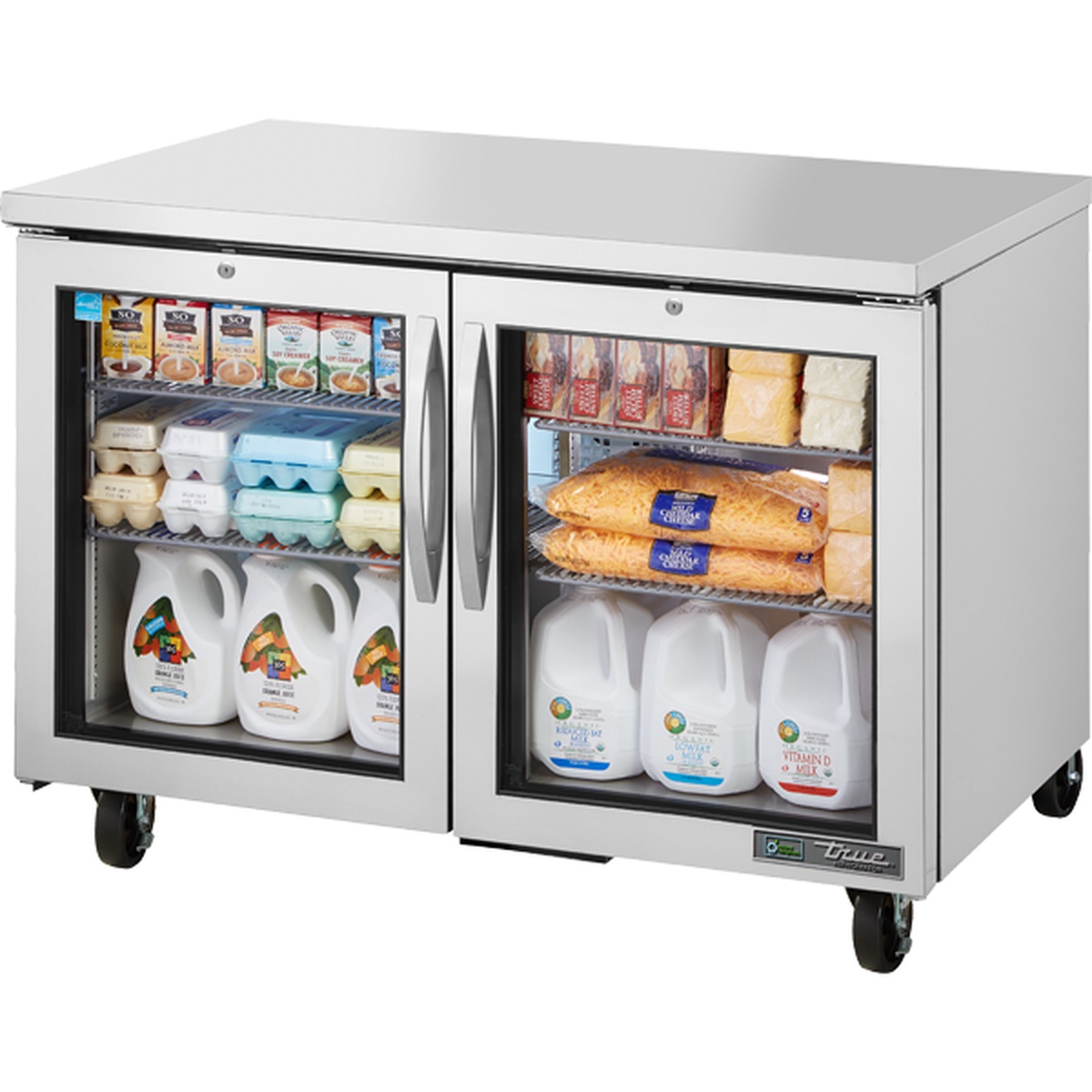 True TUC-48G-HC~FGD01 two-section undercounter refrigerator with framed glass doors, stainless steel exterior, and wire shelves stocked with dairy and packaged food items