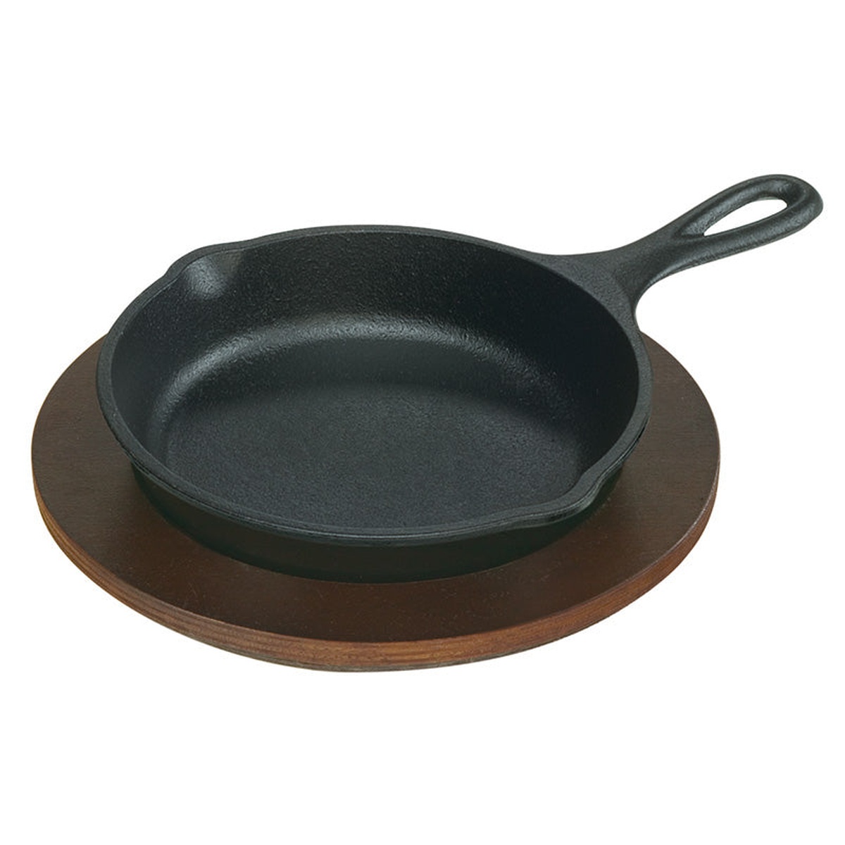 Lodge cast iron skillet resting on a round walnut wood underliner against a white background