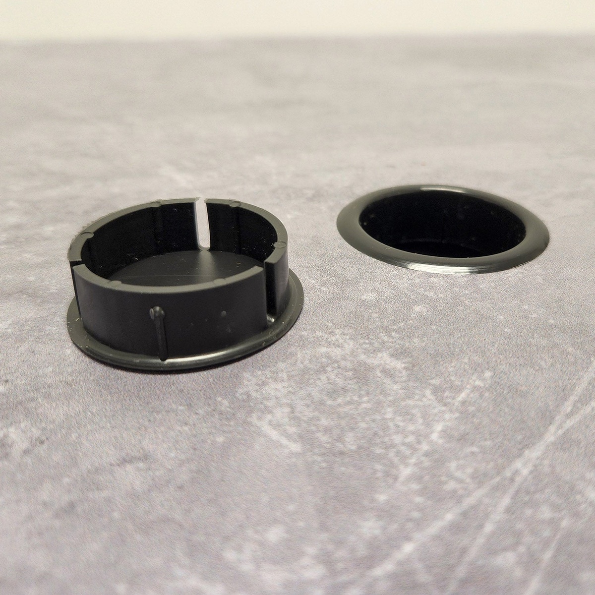 Close-up of Aquaba table umbrella hole insert and removable cap accessory on the zinc tabletop surface