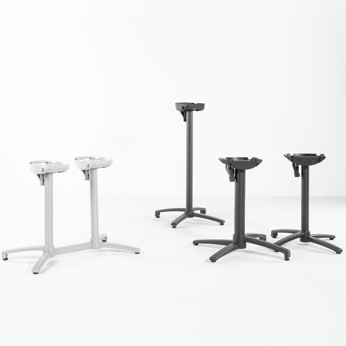 Grosfillex X-One table bases displayed in multiple sizes and finishes including silver gray and black