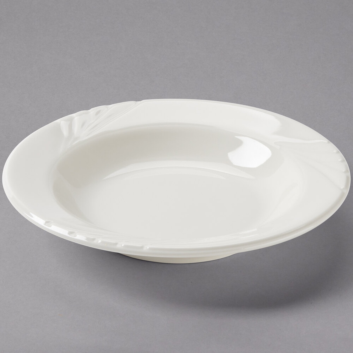 Tuxton YED-084 Monterey 9 oz. eggshell embossed rim china soup bowl, angled view showing embossed wing-like rim detail